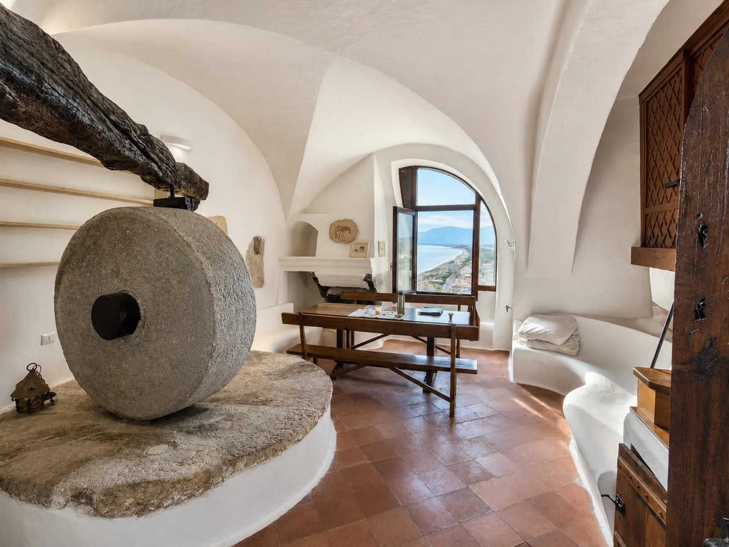 L’antica macina in pietra ripresa frontalmente nella zona giorno di Suite Il Mulino